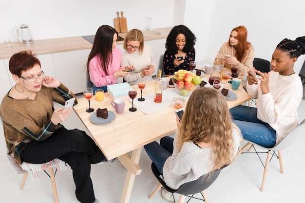 Donne dell'angolo alto che osservano sui loro telefoni