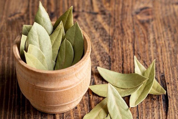 High angle of wooden bowl with bay leaves