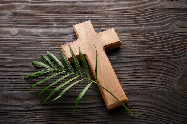 High angle wooden cross and green leaf