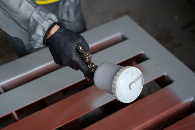 High angle worker spraying powder paint from a gun