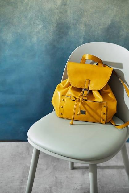 Желтая сумка под высоким углом на стуле