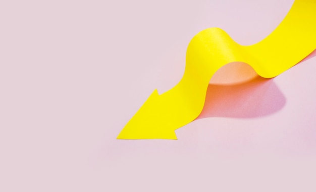 High angle of yellow paper arrow and copy space