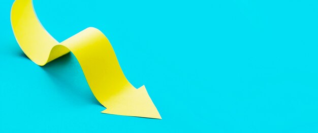 High angle of yellow paper arrow with copy space