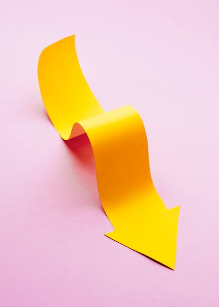 High angle of yellow paper arrow