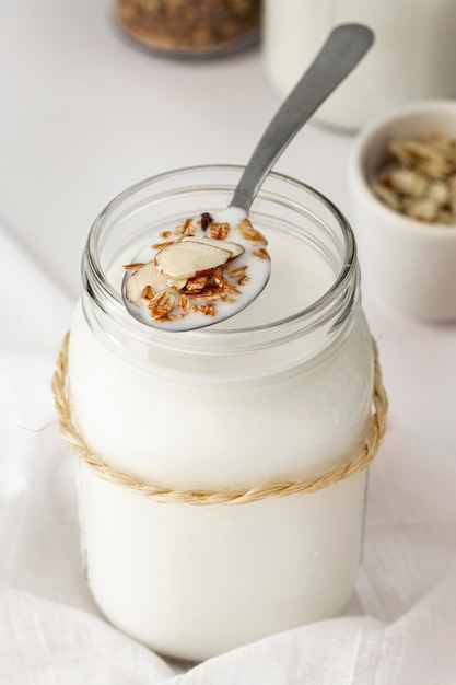 Foto gratuita barattolo di yogurt ad angolo alto con cucchiaio