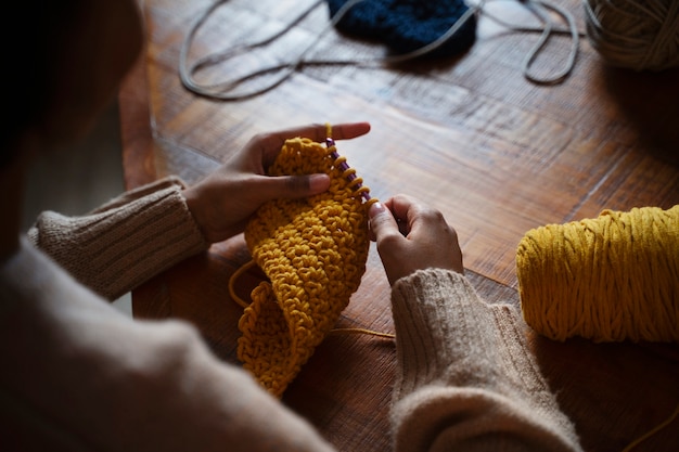 High angle young adult crocheting indoors