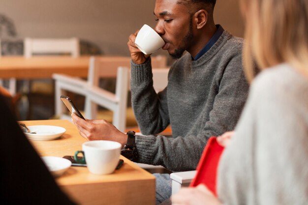 コーヒーを飲む高角の若い友人