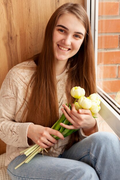 Foto gratuita ragazza dell'angolo alto con i fiori