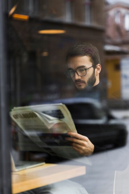 High angle young mal e reading newspaper