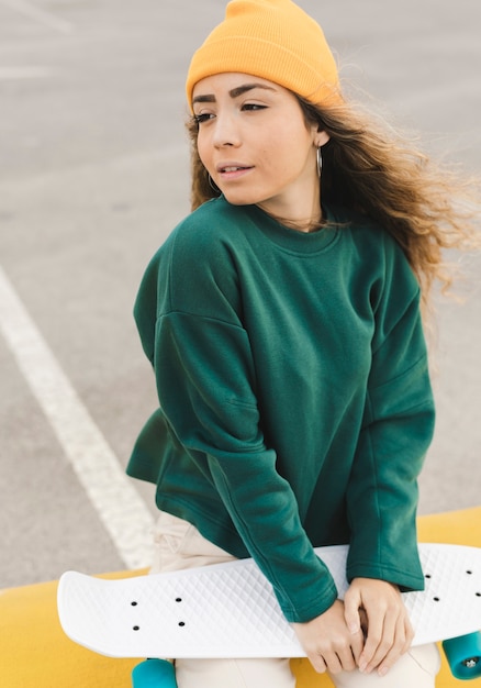 High angle young woman holding skateboard