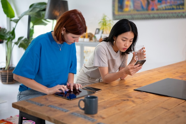 High angle young women with devices