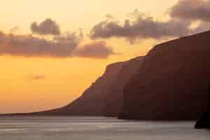 Foto gratuita alte scogliere sul mare al tramonto