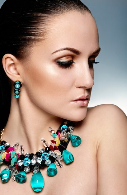 High fashion look. glamor closeup portrait of beautiful brunette Caucasian young woman model with healthy hair and green accessory jewelry