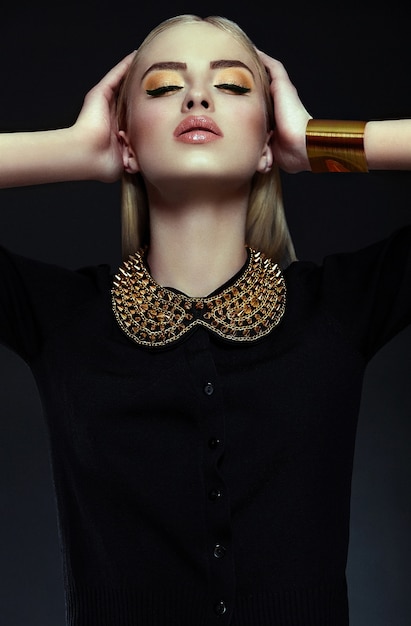 Free photo high fashion look.glamor closeup portrait of beautiful sexy stylish blond  young woman model with bright yellow makeup  with perfect clean skin with gold jewelery in black cloth