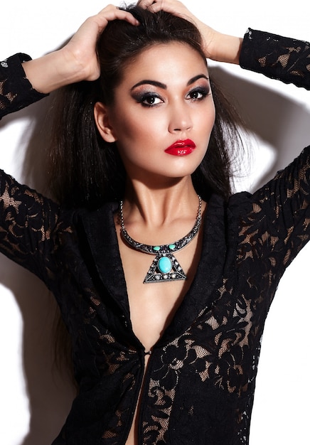 High fashion look.glamor closeup portrait of beautiful sexy stylish brunette Caucasian young woman model with bright makeup, with red lips,  with perfect clean skin with jewelery in black cloth