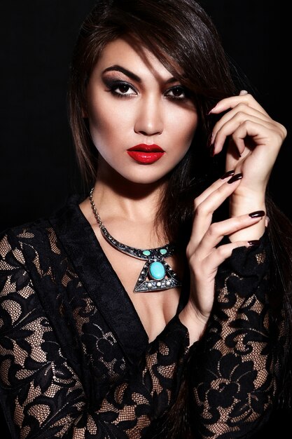 High fashion look.glamor closeup portrait of beautiful sexy stylish brunette Caucasian young woman model with bright makeup, with red lips,  with perfect clean skin with jewelery in black cloth