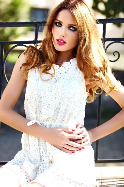 街の白い夏のドレスで完璧なきれいな肌と明るいメイクとピンクの唇と美しいスタイリッシュな金髪の若い女性モデルのファッション性の高いlook.glamorのクローズアップの肖像画