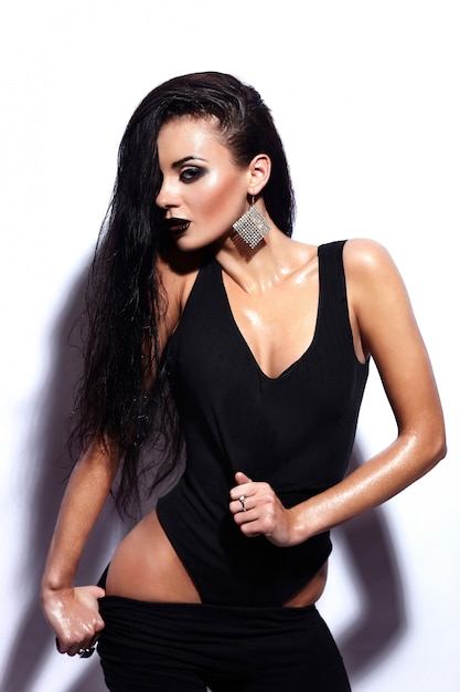 High fashion look.glamor portrait of beautiful sexy stylish brunette Caucasian young woman model with black lips,bright makeup, with perfect clean wet skin in black cloth