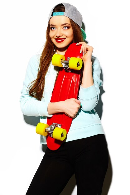 High fashion look.glamor stylish sexy beautiful young brunette woman model in summer bright hipster cloth with skateboard