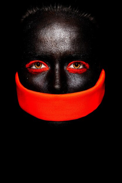 High fashion look.glamour fashion beautiful black American woman in black mask with orange bright makeup and orange material