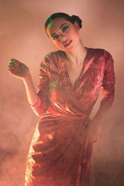 High Fashion model woman in colorful bright lights posing in studio,