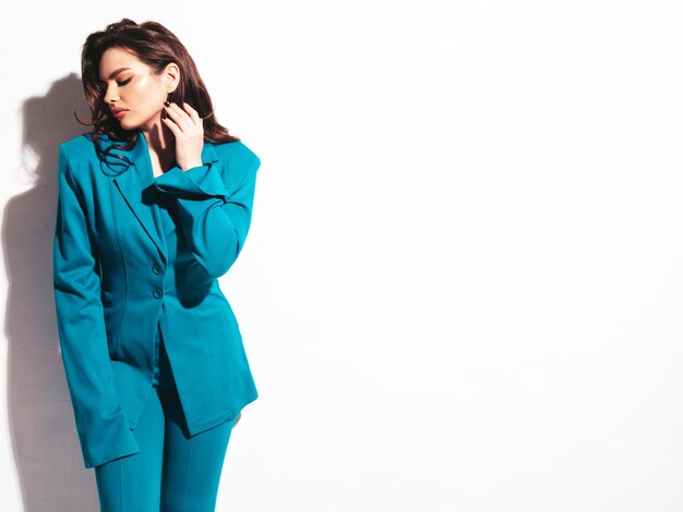 High fashion portrait of young beautiful brunette woman wearing nice trendy blue suit Sexy fashion model posing in studio Fashionable female isolated