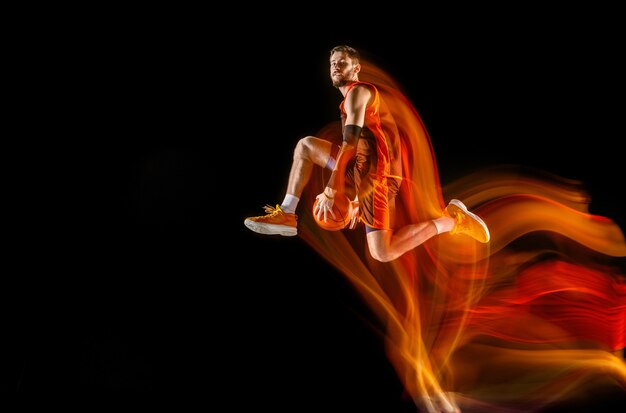 Foto gratuita volo alto. giovane giocatore di pallacanestro caucasico della squadra rossa in azione