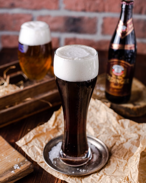 High glass of black beer with foam