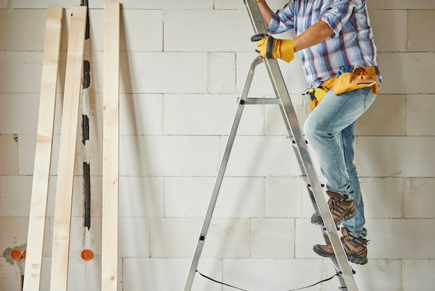 High ladder as a support for carpenter worker