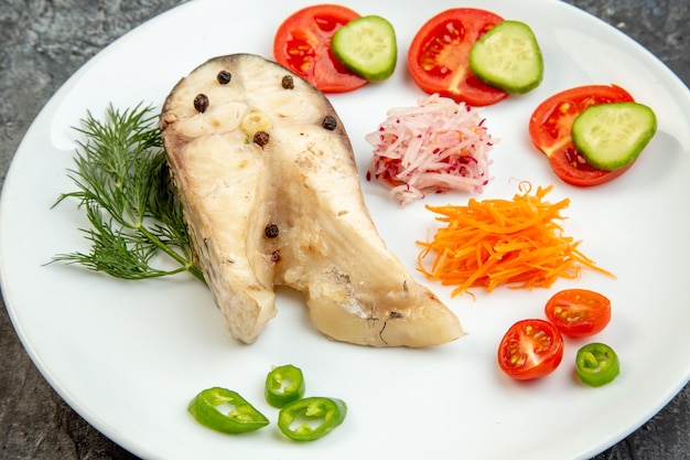 High resolution photo of raw fishes and pepper chopped fresh foods on white plate on ice surface with free space