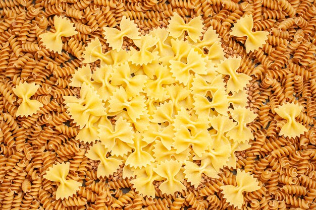 High resolution photo of various kinds of raw Italian pastas arranged in a circle in overhead view