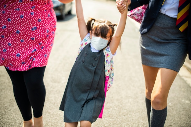 Free photo high school student wearing masks on their way home