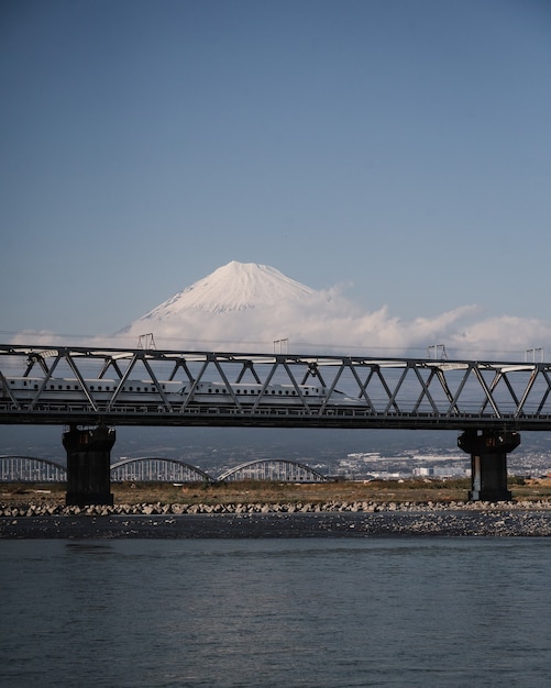 Free photo high-speed shinkansen train over fuji river with a mesmerizing fuji mountain