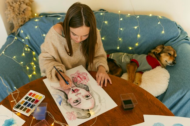 High view artist painting a portrait sitting next to a dog