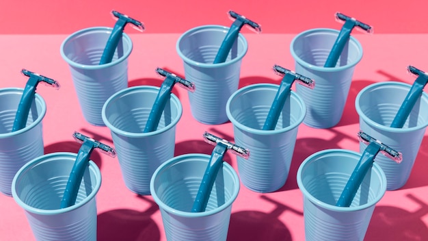 Free photo high view blue plastic cups and blue razor blades