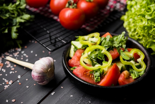 Free photo high view bowl of salad and garlic