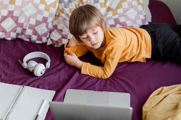 High view boy learning from his laptop