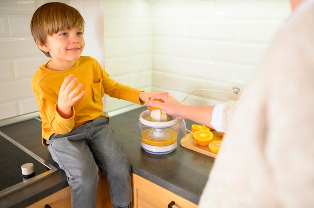 High view child making orange juice