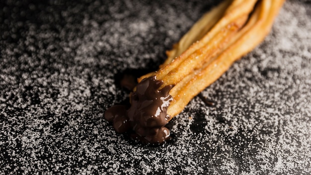 Free photo high view churros dipped in chocolate