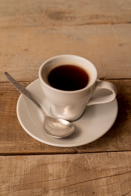 High view cup of coffee with wooden background