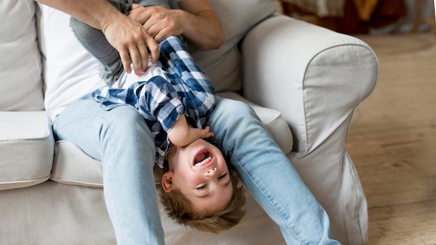 Free photo high view father tickling happy child