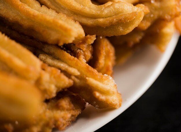 High view fried churros on a white plate