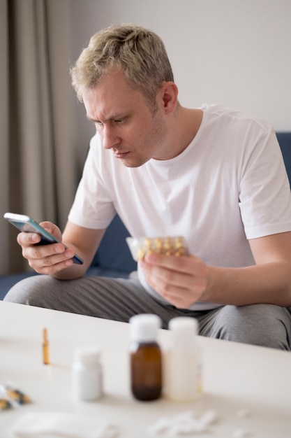 High view man holding  pills and mobile phone