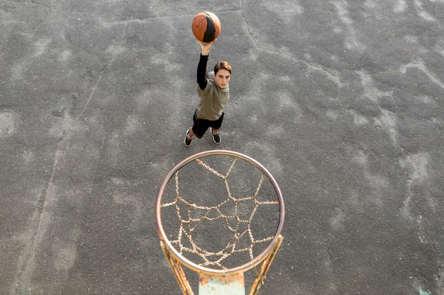Foto gratuita uomo di alta vista che getta una pallacanestro