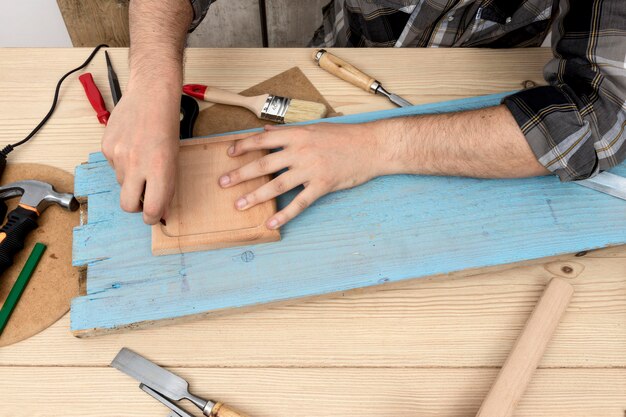 High view man using a pencil on wood