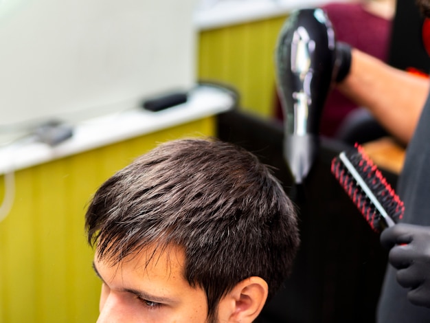 無料写真 クライアントの髪を乾燥させるヘアスタイリストの高いビュー