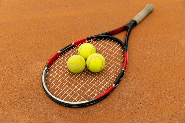 High view racket and tennis balls on court ground