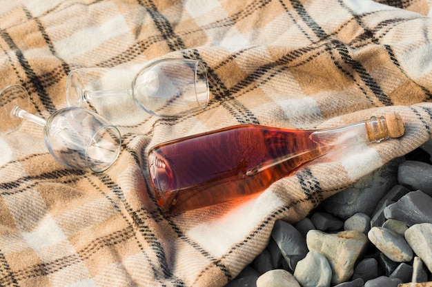 High view red wine and glasses on cloth outside