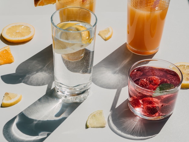 Foto gratuita ampia varietà di contenitori con acqua e succo naturali