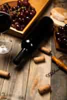 Бесплатное фото Бутылка вина высокого вида на деревянный стол